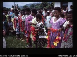 'Arrival, young girls hold leis to give us'