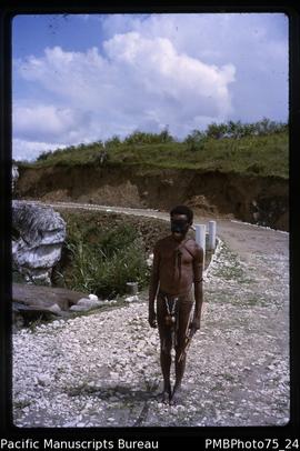 Western Highlands [portrait of man on road wearing sporran and string bag, carrying arrows]