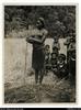 Pregnant woman about to work in garden in the Mt Hagen area. Men and children looking on.