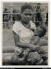 Native policeman's wife from Lae with baby (aged 4 months) stationed with husband at Mt Hagen Pol...