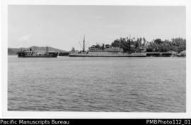 Samarai [Island, Milne Bay District; approaching by boat, two ships near wharf, one the MV Malait...