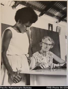 European woman teaching sewing to Ni-Vanuatu girl