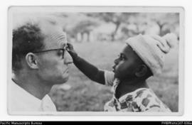 Man with young child gripping his glasses