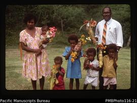 'Pastor Peter and family holding decorated yams'