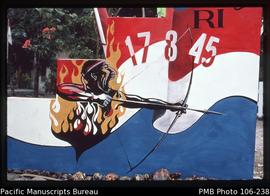 [Timika, independence day decoration 1997. Officially the Papuan man with drawn bow is fighting a...