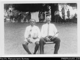 Two ni-Vanuatu men, one holding a sceptre and one holding a Bible