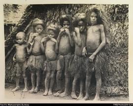 Young boy with five girls standing outside dwelling, Big Nambas area, Malekula