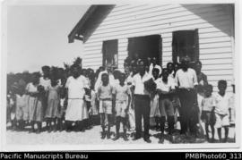 Group of ni-Vanuatu people ouside weatherboard building