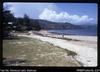 Ela Beach, P.M. [Port Moresby], looking east.  Papuan raking rubbish off sand.