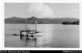 Samarai [Island;  Milne Bay District;  approaching  Samarai, boat with crew on deck]