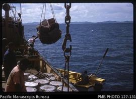 'Discharging net of empty sacks and general cargo into punt off Kanacea Island, Fiji'
