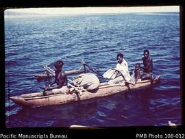 [Group on outrigger canoe]