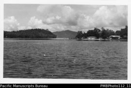 Kwato [Island, Milne Bay District, buildings and boat;  taken from boat]