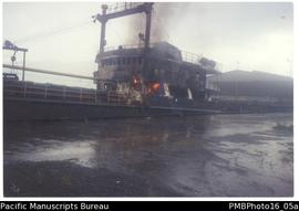 Burning ship at wharf.