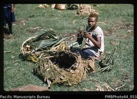 "Woman making basket from coconut palm frond, Rabaul"