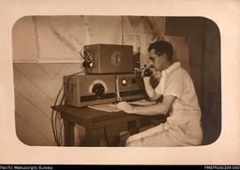Conrad Stallan operating radio equipment, probably Malekula