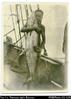 Solomon Islands man holding a large Kingfish on deck of ship. In pencil, on back of photo: ''More...