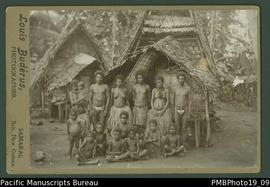 Mounted photograph of a Papua New Guinean group (men, women and children) standing and seated in ...