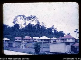 Lae [view of houses with tennis court in foreground, Morobe District]