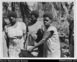 Three ni-Vanuatu women holding a container