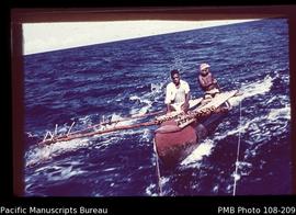[Two men on outrigger canoe]