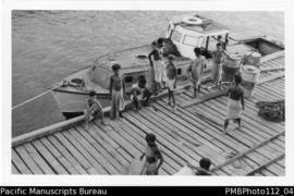 Off to Gesila [Island], Samarai, Milne Bay District;  looking down on wharf, boat Esaa’ala (?), r...