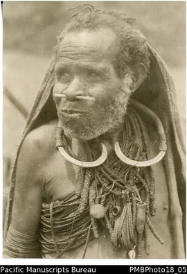 Old man wearing a traditional full length tapa cape adorned with the valuable pigs tusk neck orna...
