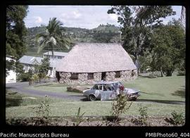 Car parked in front of a thatched building