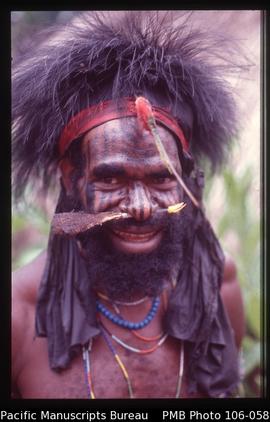 [Dani man with cassowary feather headdress and bone (pig?) through his nasal septum]