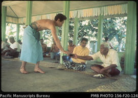Serving kava and distributing fine at a meeting in 1977.  Moeono in orange shirt, Upolu, Samoa