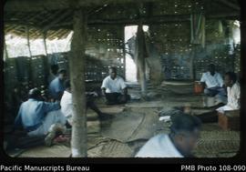[Group of ni-Vanuatu men seated inside house]