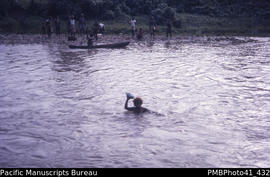 Girl crossing flooding Tailoa River, Malaita