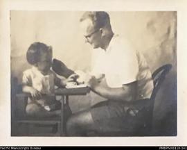 'Janet Margaret. November 1940 13 months', being fed by her father Conrad Stallan.