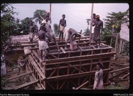 'Mixing and pouring concrete into the water tank formwork at Sikile Village, Roviana Lagoon'