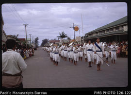 'Boys' school marching past Burns Philp's store towards the Palace, Tonga'