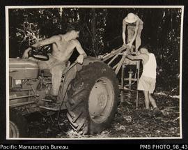 Three men drilling hole using tractor