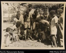 Village children looking at gift book. Lamenu