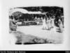 Celebration scene with Cook Islander women in dresses and picnic tables