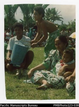 Fono and Taavili, next to a child drumming for the sasa (sitting dance) for the Pitonuu Uta villa...