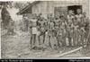 Group of men and boys, one holding a paddle (postcard). Written on front in red: 'Natives, Gracio...