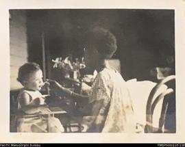 'Janet Margaret. November 1940 13 months', being fed by Malekulan woman in Wintua mission house, ...