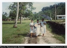 Lina, Tatu, and Tautino with baby Katerina waslking to church for the baptism. Tafua Tai, Savaii