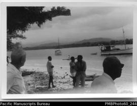 Moli Rani and group of men on shore/beach