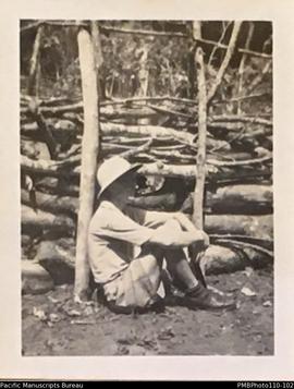 Man sitting on ground, possibly E.O. Cox, Mindu, Malekula