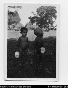 Two ni-Vanuatu boys, each holding enamel mug