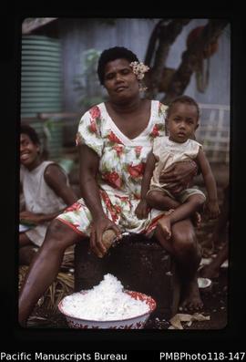 'Woman grates coconut and mission baby, Efate'