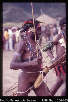 [Man holding a reed arrow, typical Lani penis sheath. Lani men from Wunin village whoop it up dur...
