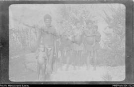 Man with three women and three children standing outside, probably Wintua, South West Bay, Maleku...