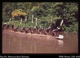 Men paddling dugout War canoe, Asmat