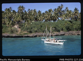 'Closeup view of two sailing cutters set against island, Tonga'